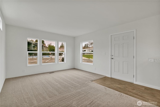 carpeted empty room with visible vents