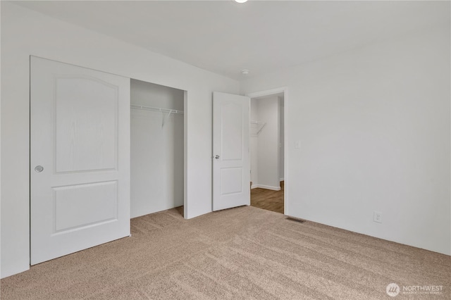 unfurnished bedroom featuring a closet, visible vents, and carpet floors