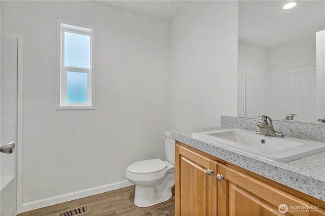 bathroom featuring visible vents, toilet, wood finished floors, baseboards, and vanity