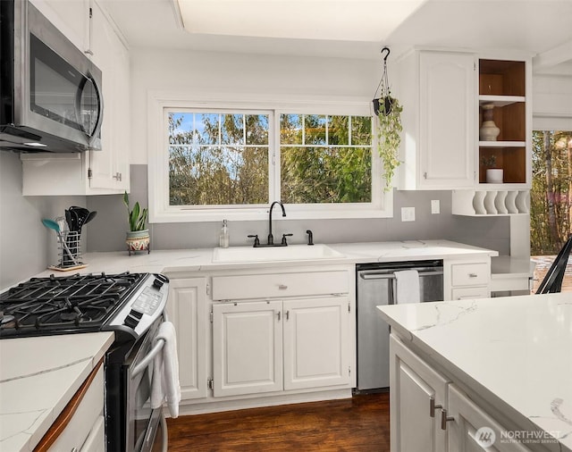 kitchen with a sink, dark wood-type flooring, white cabinets, stainless steel appliances, and open shelves