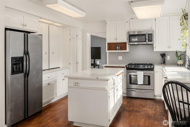 kitchen with a center island, white cabinetry, stainless steel appliances, and a sink