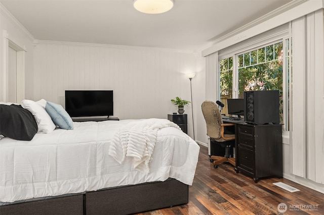 bedroom with dark wood finished floors, crown molding, and visible vents