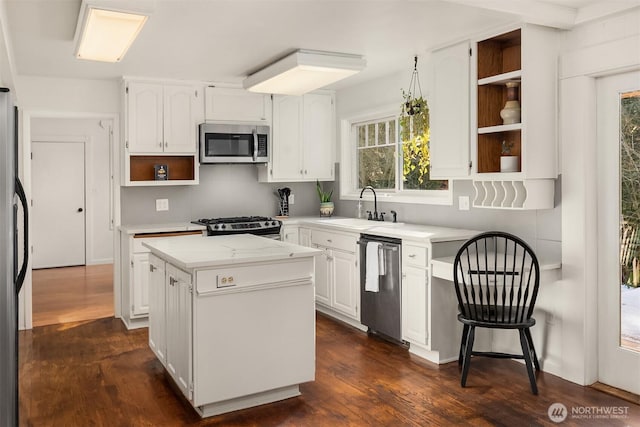 kitchen featuring a sink, open shelves, white cabinets, and stainless steel appliances