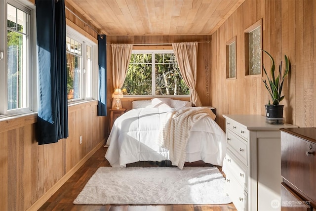 bedroom with dark wood-type flooring, wooden walls, multiple windows, and wood ceiling