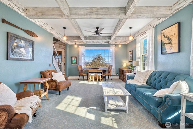 carpeted living room featuring stairs, beamed ceiling, a healthy amount of sunlight, and baseboards