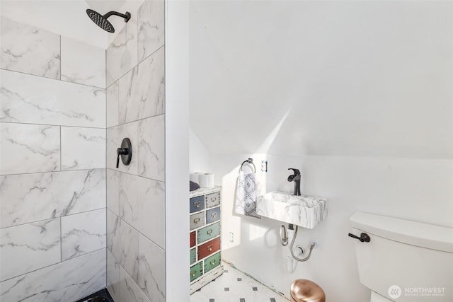 full bathroom featuring lofted ceiling, toilet, and a tile shower