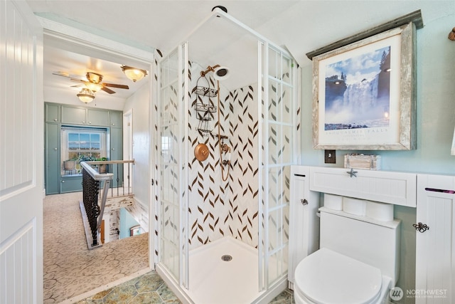 bathroom featuring a shower stall, toilet, and ceiling fan