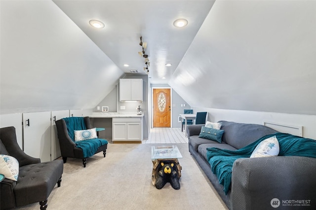 living area featuring visible vents, light carpet, and vaulted ceiling