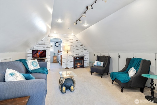 living room featuring track lighting, carpet flooring, and vaulted ceiling