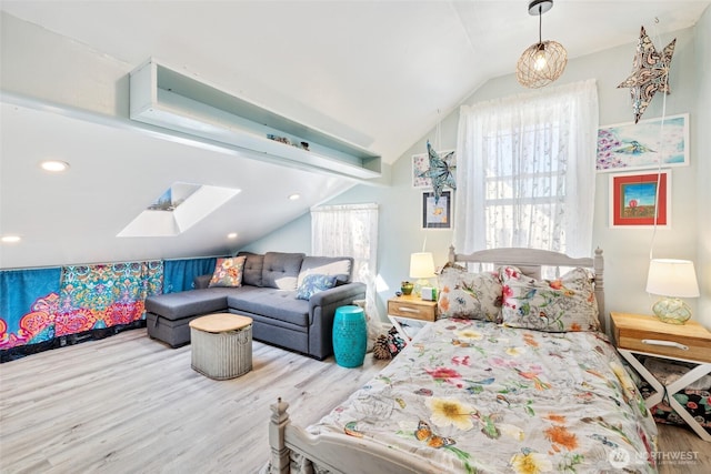 bedroom featuring vaulted ceiling with skylight and wood finished floors