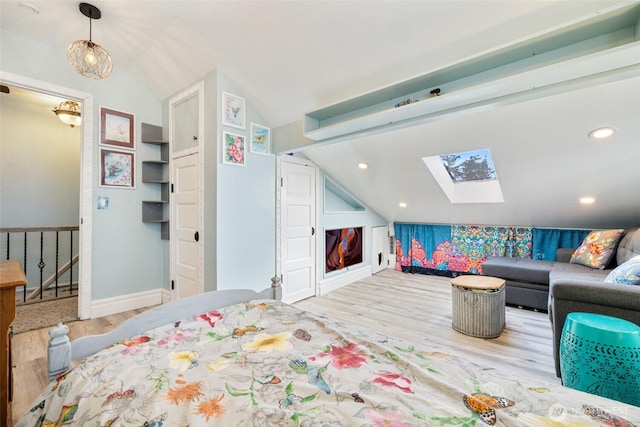 bedroom with vaulted ceiling with skylight, recessed lighting, wood finished floors, and baseboards