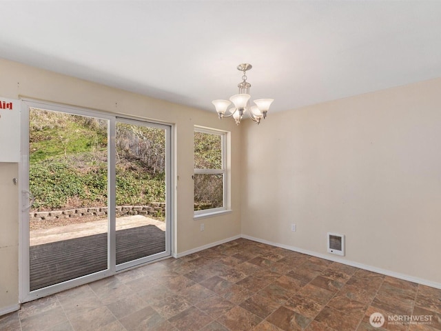 unfurnished dining area with a chandelier, baseboards, and stone finish flooring