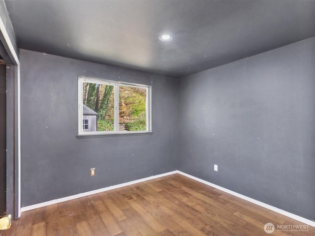 empty room with wood finished floors and baseboards