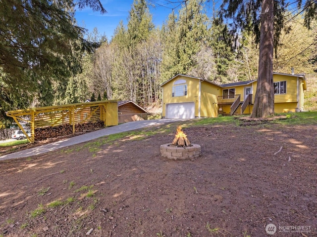 view of front of house with a wooded view, aphalt driveway, and an attached garage