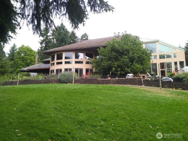 rear view of house featuring a lawn