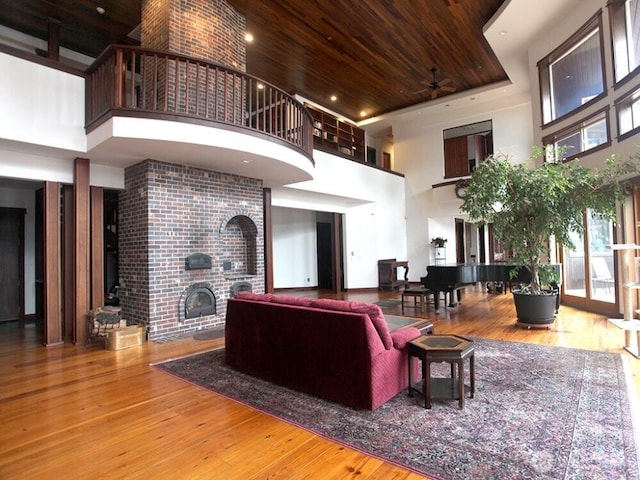 living area featuring wooden ceiling, a high ceiling, and hardwood / wood-style floors