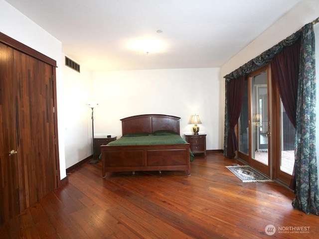 bedroom featuring baseboards, visible vents, and wood-type flooring