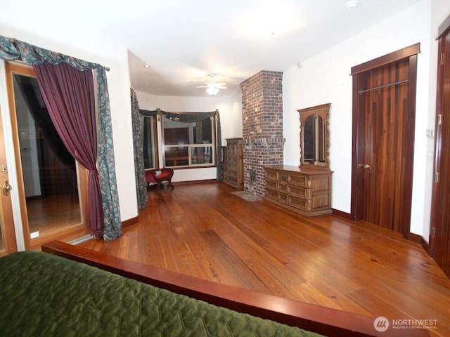 unfurnished living room with baseboards, wood finished floors, and a ceiling fan