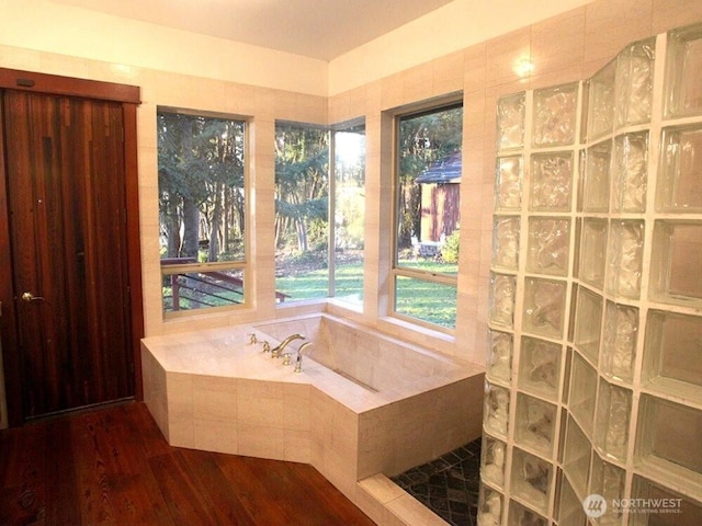 full bath with a bath, a walk in shower, and wood finished floors