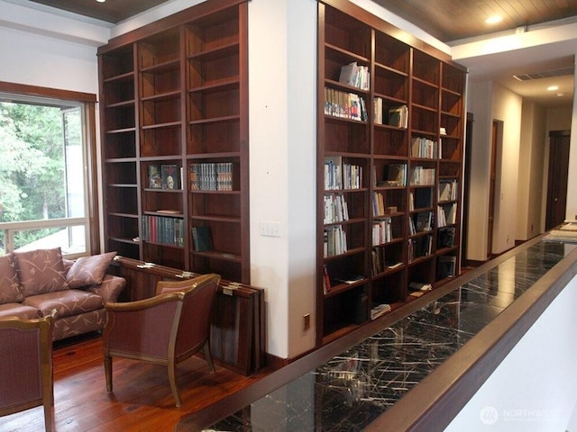 living area featuring recessed lighting, wood finished floors, visible vents, and built in shelves