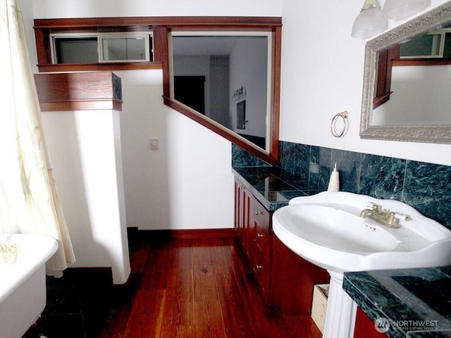 full bath with a bathing tub and wood finished floors