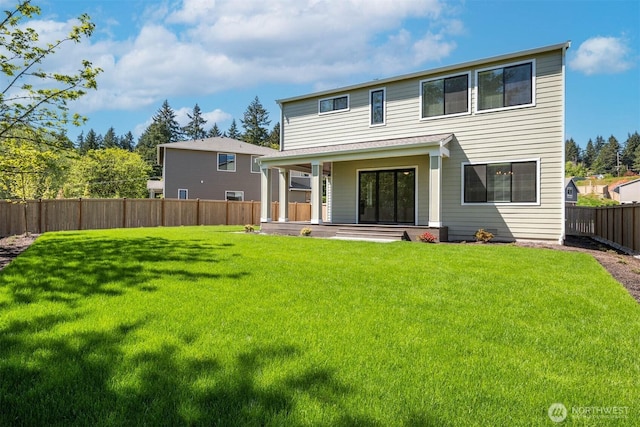 rear view of property with a yard, a porch, and a fenced backyard