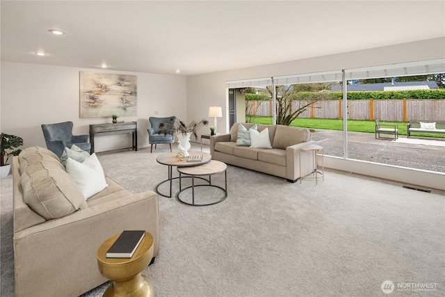 carpeted living area with visible vents and recessed lighting