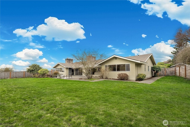 back of house with a yard, a fenced backyard, and a patio area