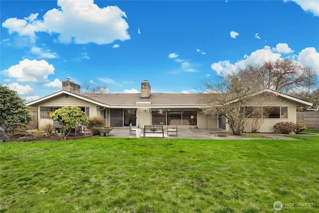 rear view of property with a patio area, a chimney, and a yard