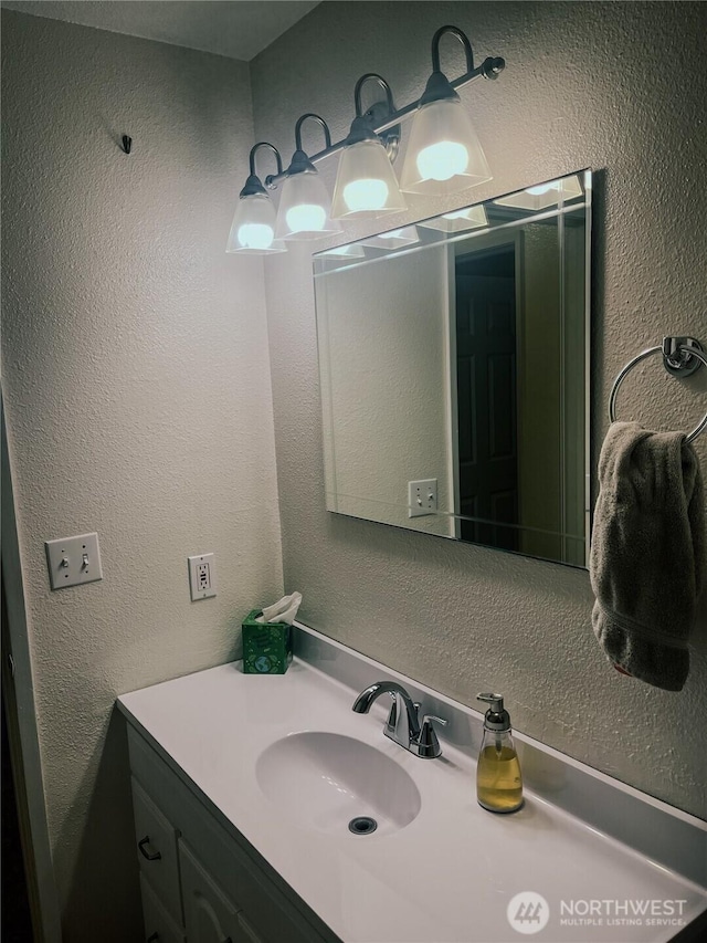 bathroom featuring vanity and a textured wall