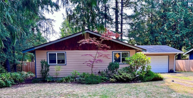 exterior space featuring a lawn, a garage, and fence