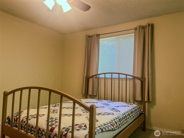 bedroom with baseboards, a textured ceiling, and a ceiling fan