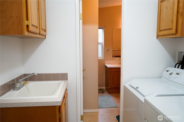 laundry area with cabinet space, washer and dryer, and a sink