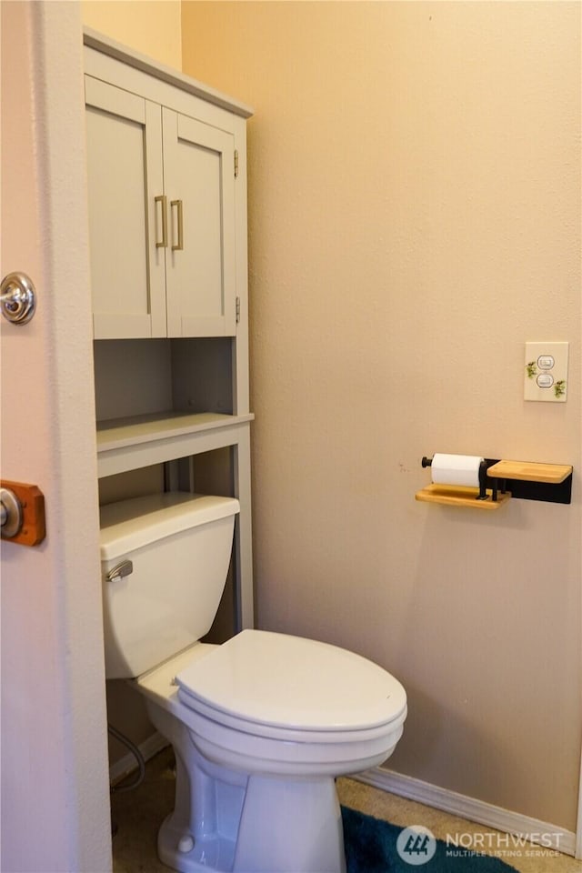 bathroom featuring baseboards and toilet