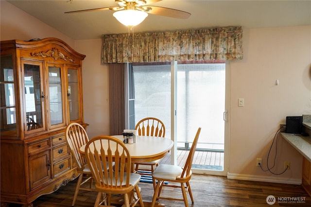 dining area with dark wood finished floors, ceiling fan, a baseboard heating unit, and baseboards