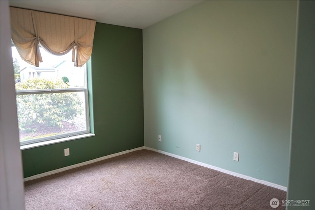 carpeted spare room with baseboards