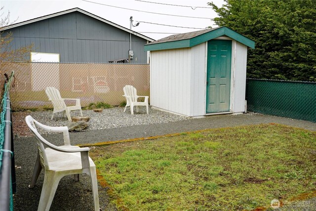 view of yard with an outbuilding, a storage unit, and fence