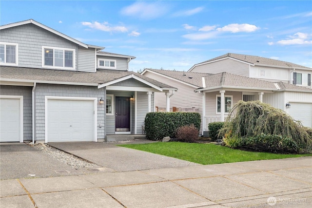 multi unit property featuring an attached garage, driveway, and roof with shingles