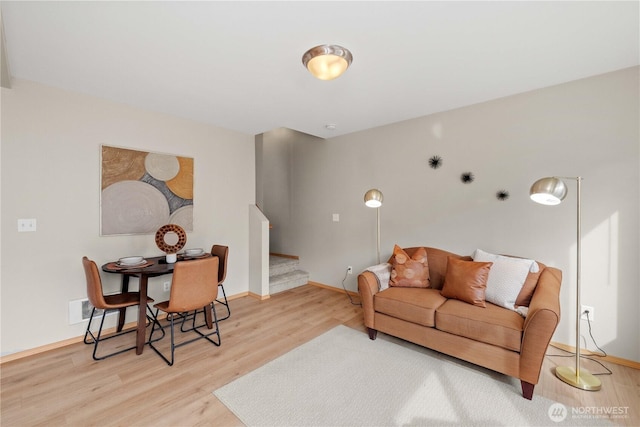 living area featuring stairway, wood finished floors, and baseboards