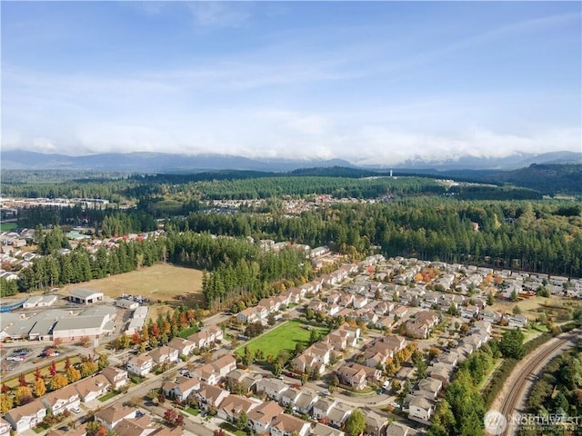 aerial view featuring a forest view, a mountain view, and a residential view