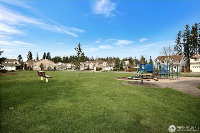 communal playground featuring a residential view and a yard