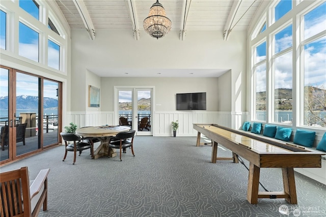 sunroom featuring a mountain view, beam ceiling, and a healthy amount of sunlight