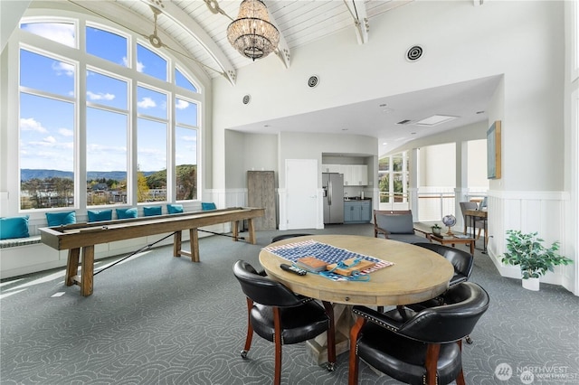 recreation room with a wealth of natural light, beamed ceiling, wainscoting, and wood ceiling