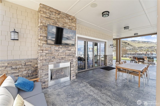 view of patio with outdoor dining space and a fireplace