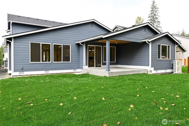 rear view of property with crawl space, a patio, and a lawn