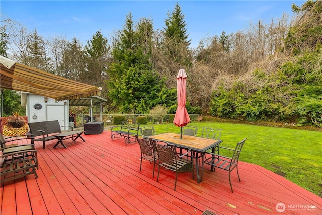 wooden deck with outdoor dining space and a yard