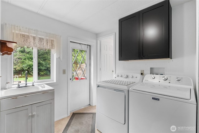 laundry area with cabinet space, independent washer and dryer, and a sink