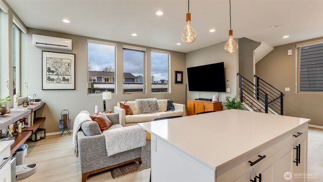 living room with recessed lighting, light wood finished floors, and a wall mounted AC