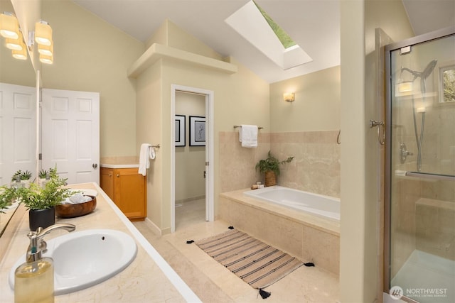 bathroom featuring a garden tub, double vanity, a stall shower, a sink, and lofted ceiling with skylight