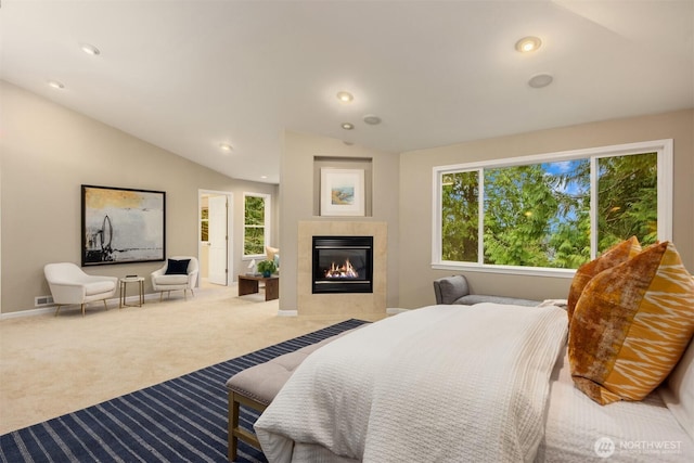 bedroom featuring a tiled fireplace, vaulted ceiling, recessed lighting, and carpet floors